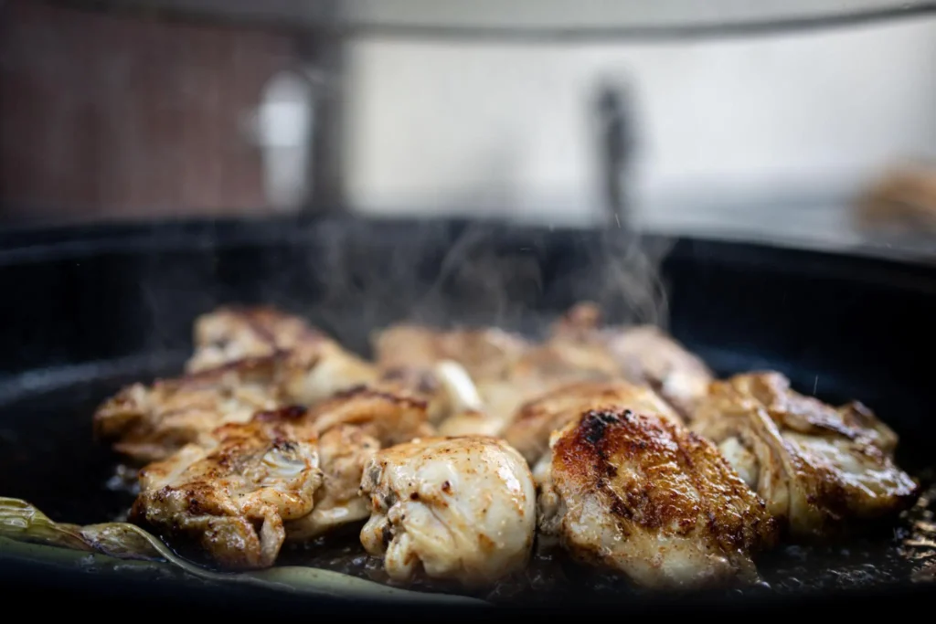 Crispy chicken sizzling in skillet until golden brown